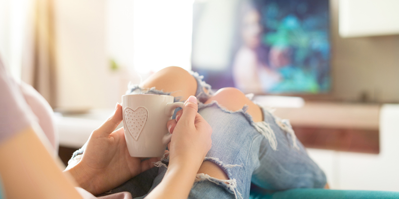girl with ripped jeans watching TV