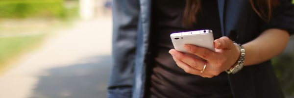 girl texting outside wearing blue jacket