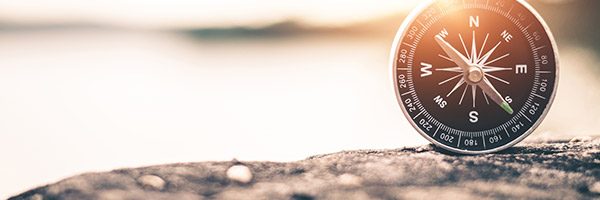 compass resting on rock face in sunlight