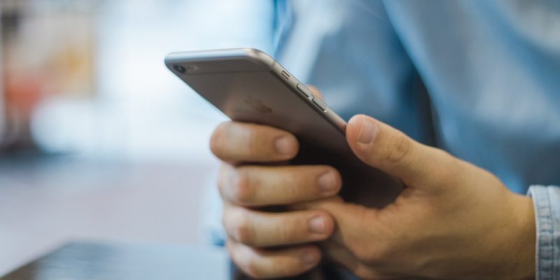 man texting on iPhone