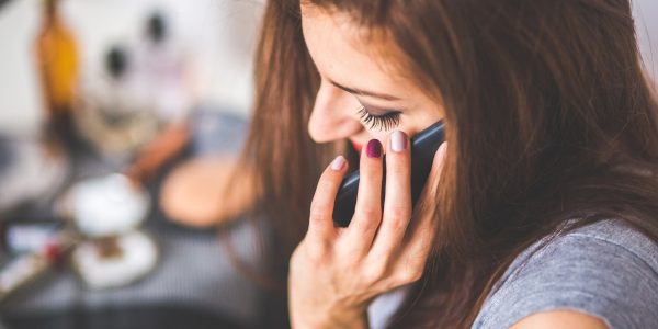 woman with painted fingernails on phone